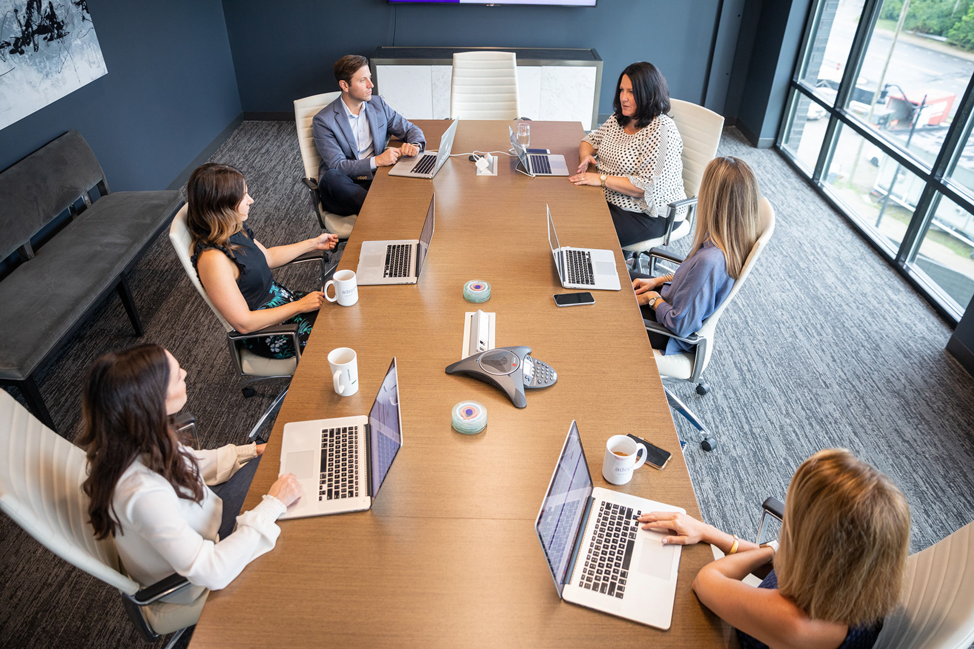 Upright team members working around conference room table